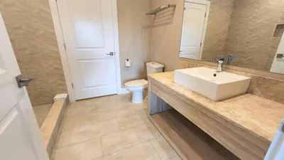 a bathroom with a white sink and a toilet at 3053 Magic Village 3 suites jacuzzi BBQ 6min Disney in Orlando