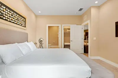 a bedroom with a white bed and a bathroom at 7562 Magic Village nice 8guests 4suites 8 min Disney in Orlando