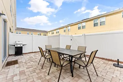 a patio with a table and chairs and a grill at 5129 Tasty renovated 8 guests BBQ near Disney in Kissimmee