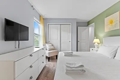 a bedroom with a white bed with a tv on it at 5129 Tasty renovated 8 guests BBQ near Disney in Kissimmee