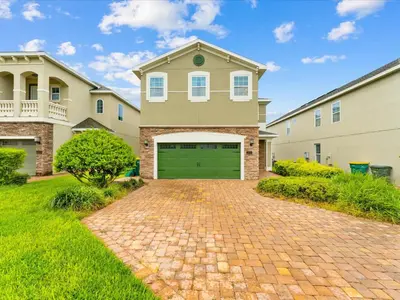a house with a green garage door on a brick driveway at Cheerful Home Near Disney With Themed Rooms, Pool Table & Waterpark And Resort Access At Encore Resorts Reunion - 200Mn in Kissimmee