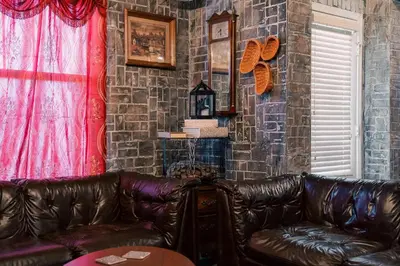 a living room with a leather couch and a brick wall at Stay at Hogwarts Harry Potter's Home, Free Parking, Pets Allowed in Kissimmee