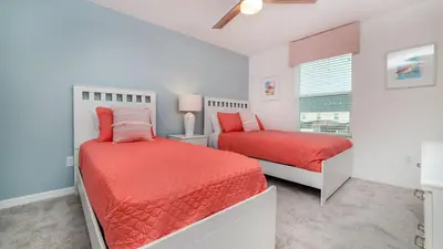 a bedroom with two beds and a window at 8972 Amelia Downs in Orlando
