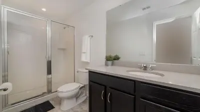 a bathroom with a toilet and a shower and a sink at 8972 Amelia Downs in Orlando