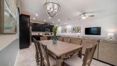a dining room and kitchen with a table and a couch at 8972 Amelia Downs in Orlando