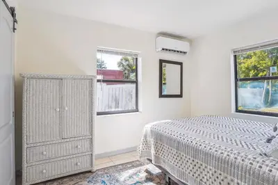 a white bedroom with a bed and two windows at 6 Mi to Downtown Orlando Quiet Home with Sunroom in Orlando