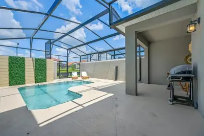 a swimming pool on a patio with a glass roof at Families Deluxe Dream Vacation 10 min from Disney in Kissimmee