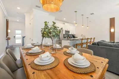 a dining room and living room with a wooden table at Families Deluxe Dream Vacation 10 min from Disney in Kissimmee