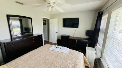 a bedroom with a bed and a dresser and a mirror at Near Disney cozy quiet place 2 privet rooms queen bed up to 4 people in Orlando