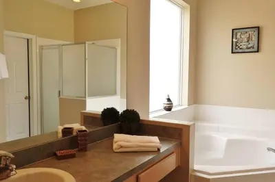 a bathroom with a sink and a tub and a mirror at Edwin Island - Luxury home, Excellent location, Gated-Community in Kissimmee