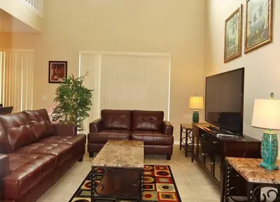 a living room with a couch and a flat screen tv at Edwin Island - Luxury home, Excellent location, Gated-Community in Kissimmee