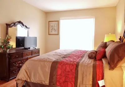 a bedroom with a bed and a dresser with a television at Edwin Island - Luxury home, Excellent location, Gated-Community in Kissimmee