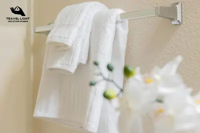 a towel rack with white towels hanging on a wall at Themed Home Near Disney World in Kissimmee