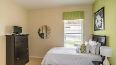 a bedroom with a bed with a dresser and a window at 2568 Archfeld in Kissimmee