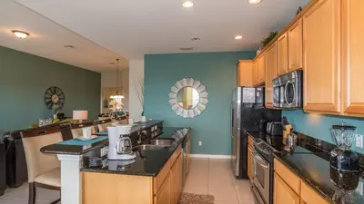 a kitchen with wooden cabinets and black counter tops at 2568 Archfeld in Kissimmee