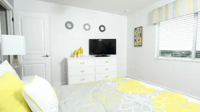 a white bedroom with a bed and a tv at 2582 Archfeld in Kissimmee