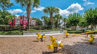 a playground with yellow toy dogs and a swing at 2582 Archfeld in Kissimmee
