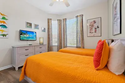 a bedroom with two beds and a flat screen tv at 2774 Almaton #403 in Kissimmee