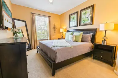 a bedroom with a bed with yellow walls and a window at 2813 Almaton #403 in Kissimmee