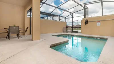 a swimming pool in a building with a table and chairs at 3027 Beach Palm in Kissimmee