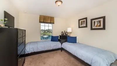 a bedroom with two beds and a dresser and a window at 3031 Beach Palm in Kissimmee