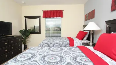a bedroom with a bed and a mirror and a television at 3043 Beach Palm in Kissimmee