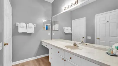 a white bathroom with a sink and a mirror at 2301 Butterfly Palm #301 in Kissimmee