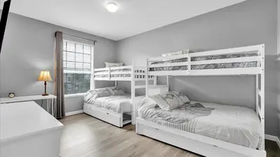 two white bunk beds in a bedroom with a window at 2301 Butterfly Palm #301 in Kissimmee