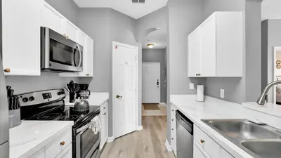 a kitchen with white cabinets and a sink at 2301 Butterfly Palm #301 in Kissimmee
