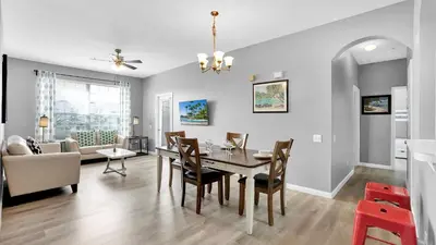 a dining room and living room with a table and chairs at 2301 Butterfly Palm #301 in Kissimmee