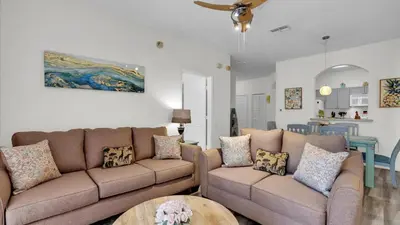 a living room with two couches and a table at 2302 Butterfly Palm #203 in Kissimmee