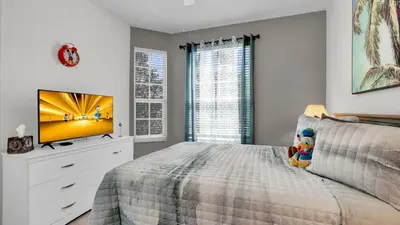 a bedroom with a bed with a tv on it at 2302 Butterfly Palm #203 in Kissimmee