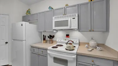 a kitchen with a white stove and a microwave at 2302 Butterfly Palm #203 in Kissimmee