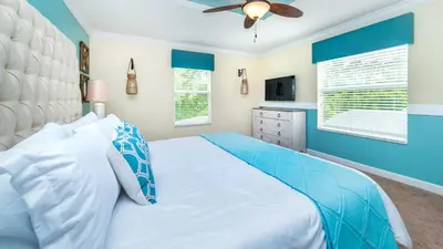 a blue bedroom with a bed and a ceiling fan at 2979 Buccaneer Palm in Kissimmee