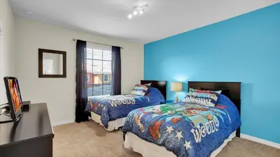 a bedroom with two beds and a television in it at 8959 California Palm in Kissimmee