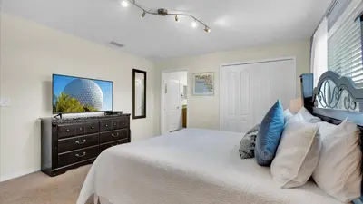a bedroom with a large bed and a dresser at 8959 California Palm in Kissimmee