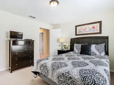 a bedroom with a bed with a black and white comforter at 8967 California Palm in Kissimmee