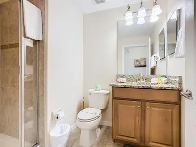 a bathroom with a toilet and a sink and a shower at 8967 California Palm in Kissimmee