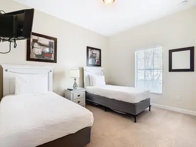 a bedroom with two beds and a flat screen tv at 8967 California Palm in Kissimmee