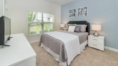 a bedroom with a bed and two lamps and a television at 3076 Juliet in Kissimmee
