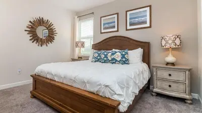 a bedroom with a bed and a nightstand and a mirror at 4797 Kings Castle in Kissimmee