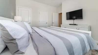 a white bedroom with a bed and a television at 4837 Lullaby in Kissimmee