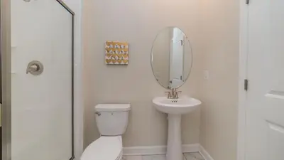 a bathroom with a toilet and a sink and a mirror at 4543 Narrative in Kissimmee