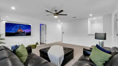a living room with leather furniture and a ceiling fan at 2718 Oxymoron in Kissimmee