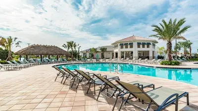 a swimming pool with chairs and a building at 3141 Pequod in Kissimmee