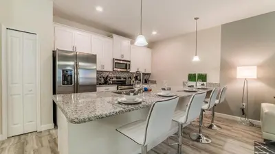 a kitchen with a bar with chairs and a counter top at 3141 Pequod in Kissimmee