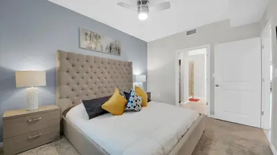 a bedroom with a large white bed with yellow pillows at 3111 Paradox #202 in Kissimmee