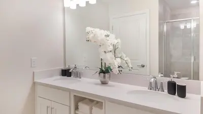 a bathroom with a sink with a vase of flowers at 3180 Paradox #303 in Kissimmee