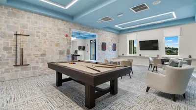 a billiard room with a table and chairs at 4361 Quote in Kissimmee