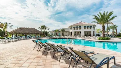 a swimming pool with chairs and a building at 4951 Windermere in Kissimmee